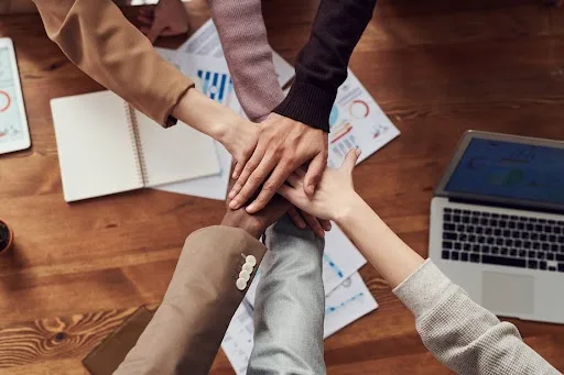 persone che uniscono le mani in centro