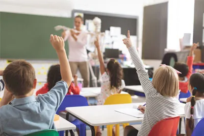 bambini in classe che alzano la mano